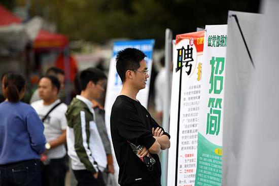 11月16日，求职者在招聘会现场查看招聘信息。 新华社记者 刘军喜 摄