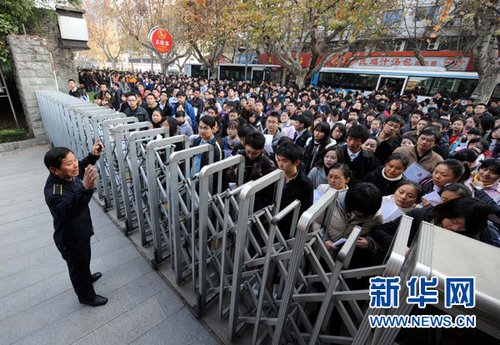 12月5日,在南京女子中专考点,一名工作人员向参加国家公务员考试的考生讲进场注意事项。新华社记者 孙参 摄